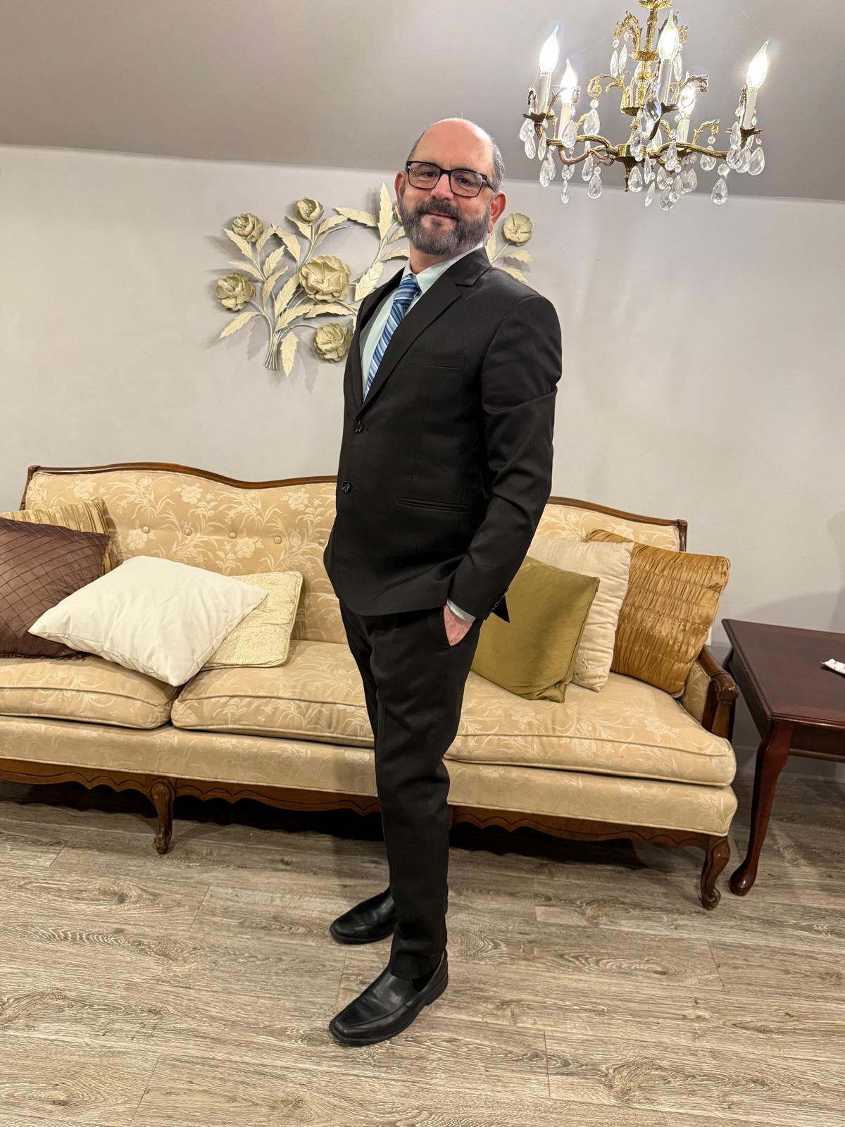 Abhay Dharmadhikari in a black suit and blue tie