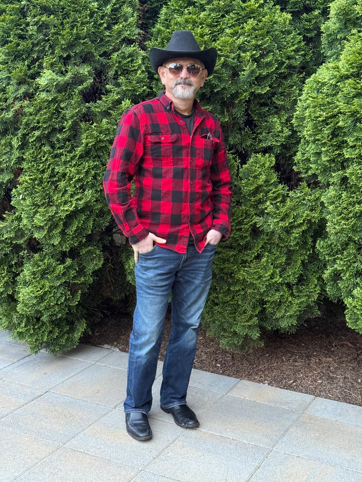 Abhay Dharmadhikari in a cowboy hat and red checked shirt