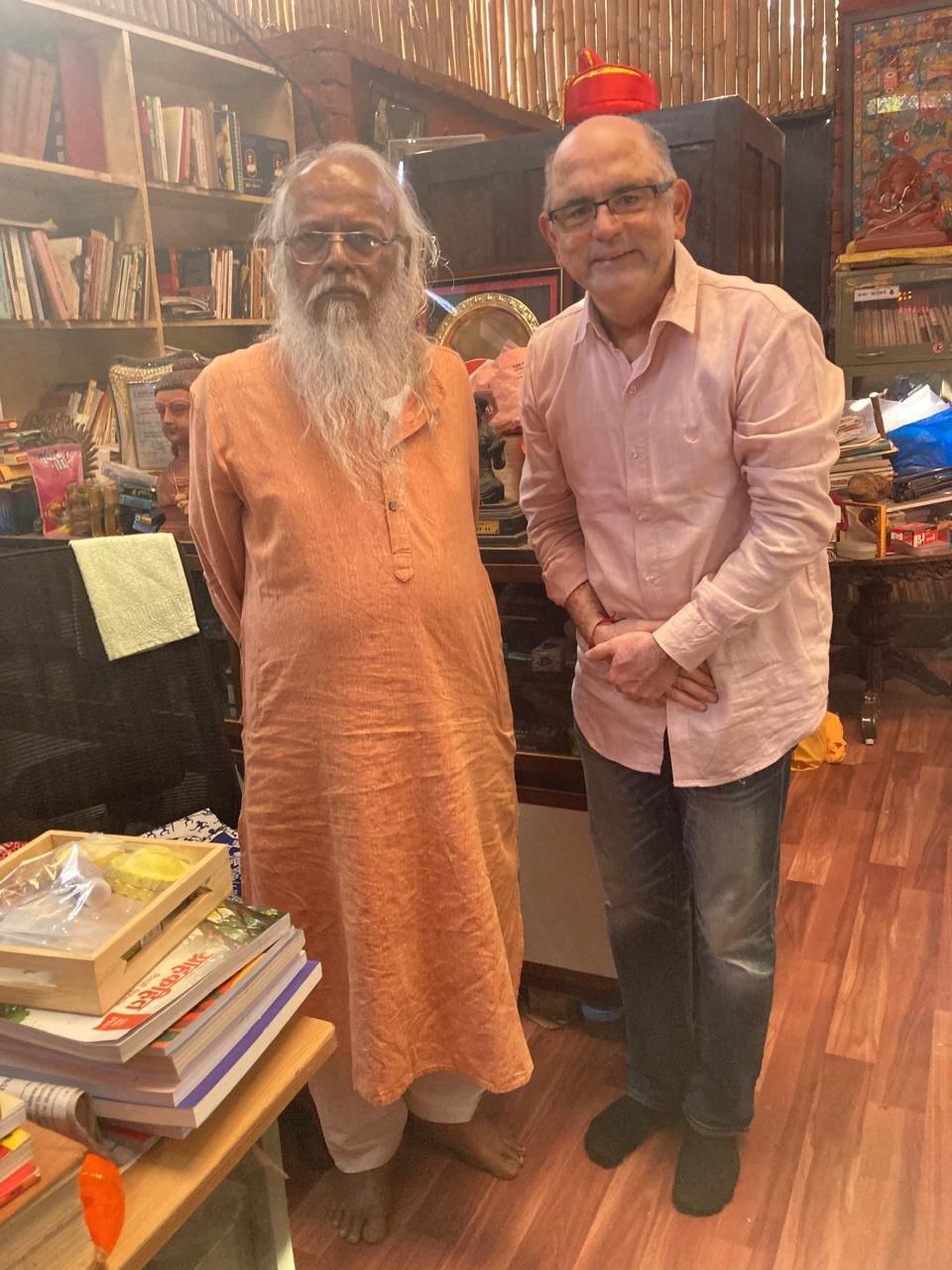 Two people standing together in a room filled with books