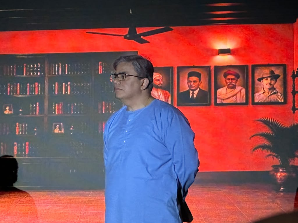 Gondya Ala Re! — a character in a blue kurta, surrounded by portraits from history.