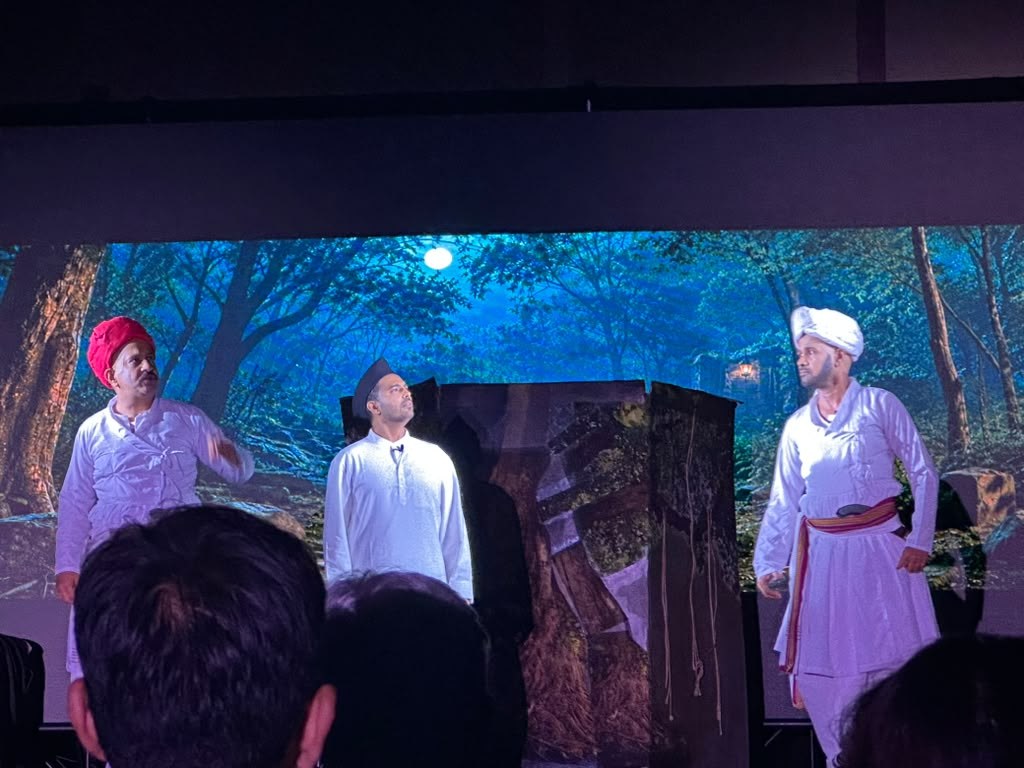 Gondya Ala Re! — an ensemble scene against a forest backdrop.
