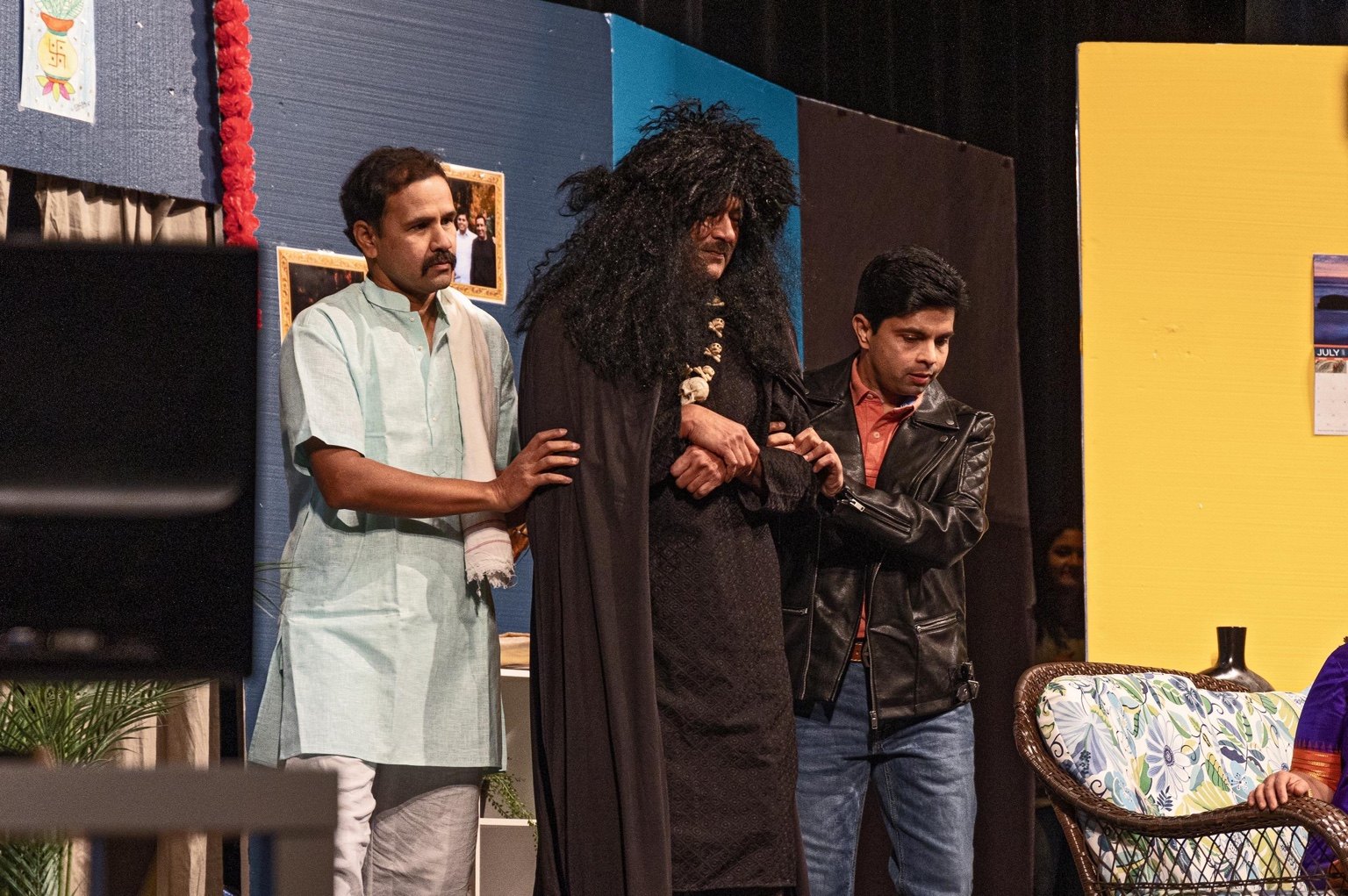 An ensemble of actors share a dramatic moment on stage